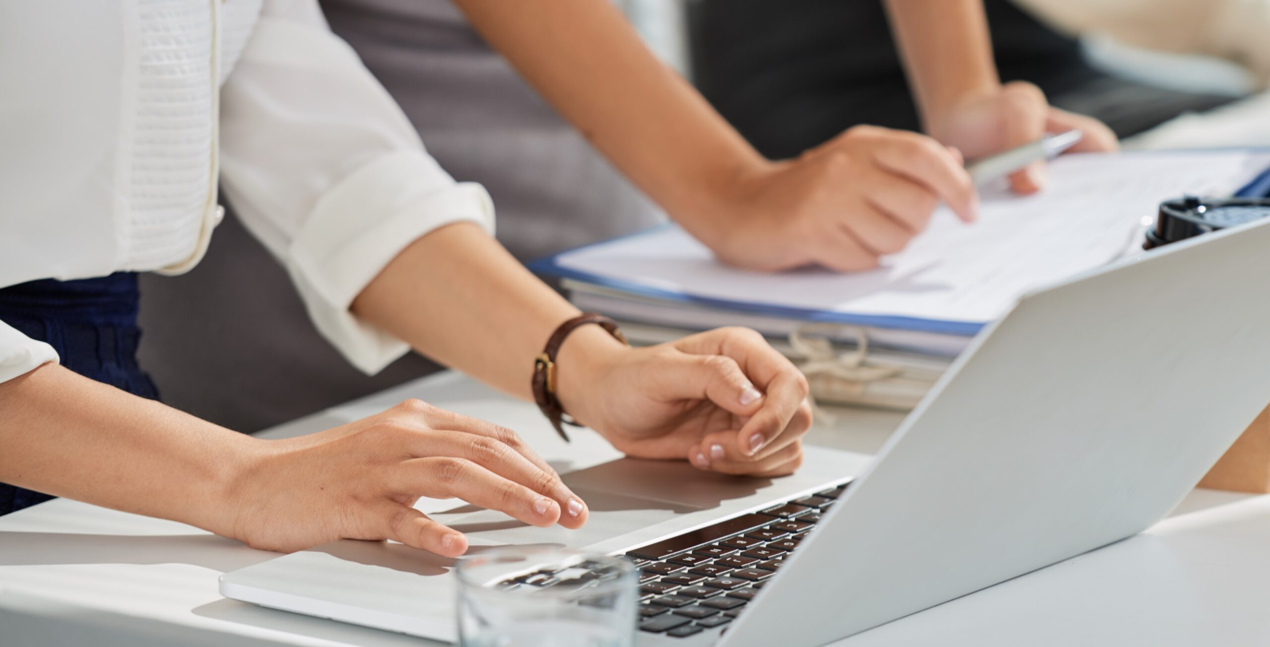 Cropped image of business ladies reading e-mails on laptop screen